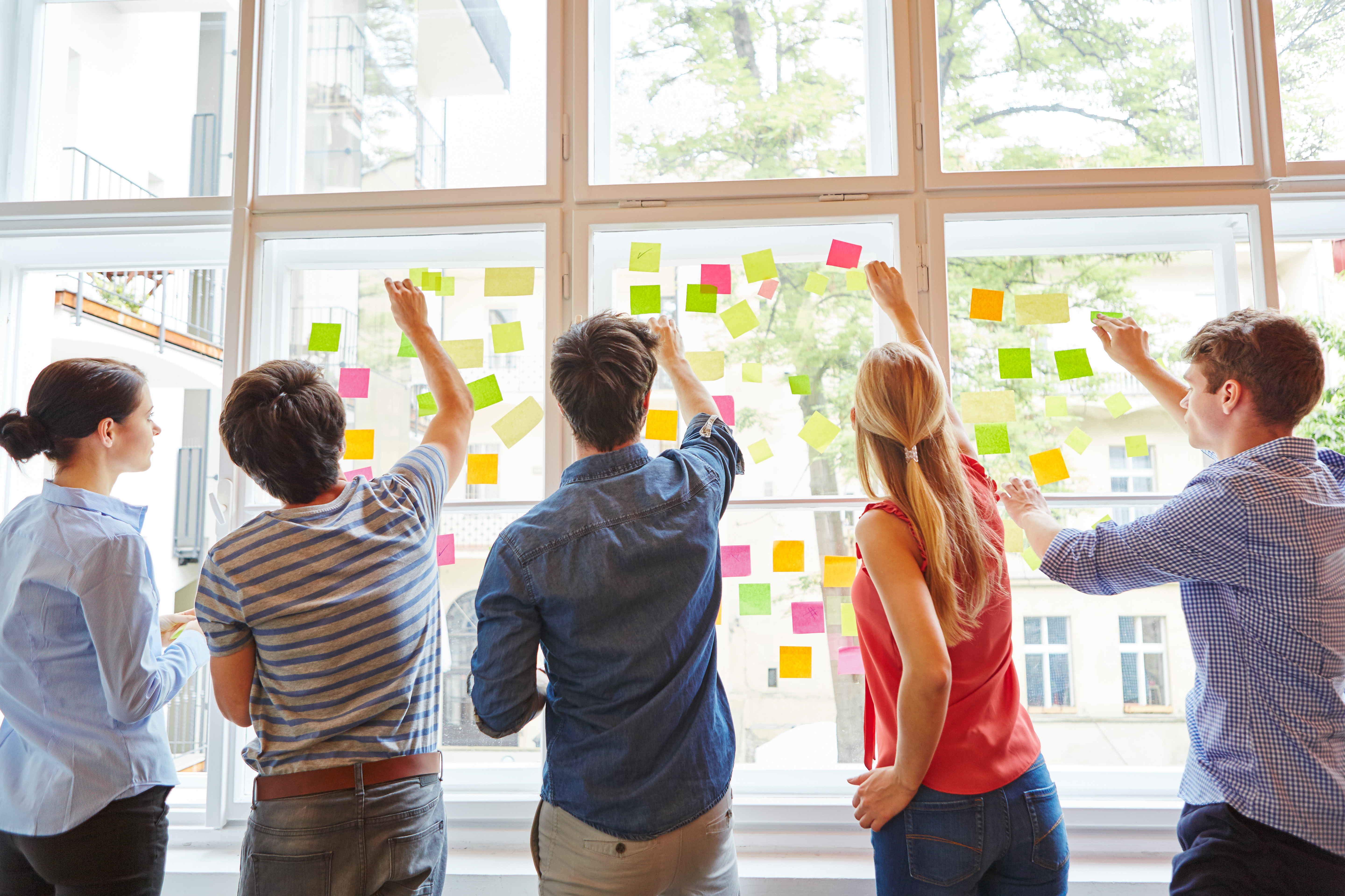 Junge Studenten im Seminar für Brainstorming mit bunten Zetteln